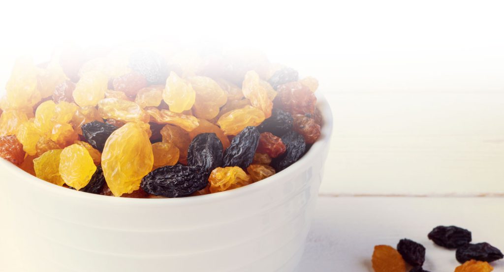 Multiple colors of raisins in a bowl
